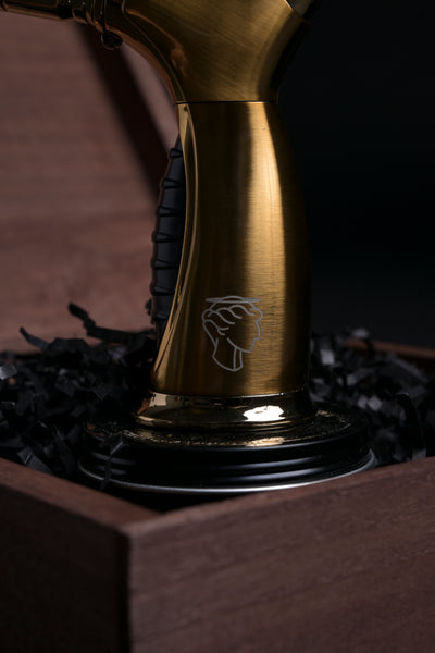 Close-up of the Helius Originals gold cocktail torch displayed in a luxury wooden box, premium barware for smoked cocktails and culinary creations.