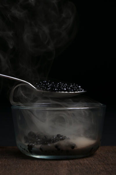 Luxury smoked caviar served in a glass dish with rising smoke, infused using Helius Originals cocktail smoker for gourmet dining experiences.