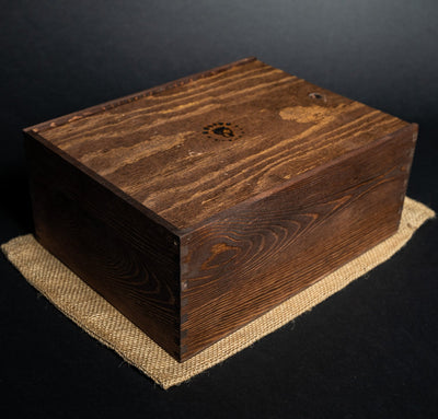 Helius Originals large wooden storage box with logo on lid, placed on burlap cloth, designed for cocktail smoking accessories and wood shavings
