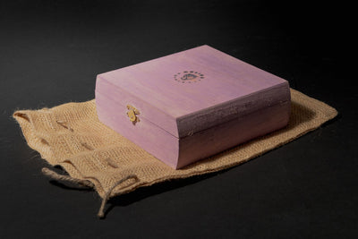 Closed pink wood smoke cocktail kit box with Helius Originals logo on a burlap bag.
